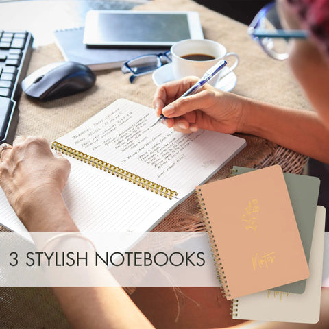 Person writing in one of the Stylish Aesthetic Spiral Notebook Set Of 3 For Women with open pages and other notebooks in view