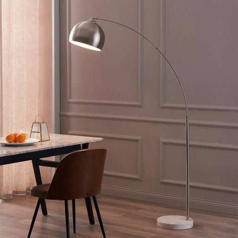 Arc Floor Lamp With Faux White Marble Base And Nickel Bell Shade For Living Rooms Offices Bedrooms Sleek Modern Mid Century Vibe Warm Ambient Task Lighting next to table and chair.