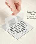 50 Pcs Disposable Shower Drain Hair Catcher 3.94" ES Square Drain applied over a shower drain for hair protection.