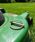 Get Your Yard Gear Fixin' With These 12 Heavy Duty Carbon Steel Retaining Pins Featuring Ring Locks For Tractors Mowers And Trailers To Keep Everything Secure And Rust-Free In The Dirt, showcasing a retaining pin on a green mower.