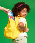 Child placing a Travel Magnetic Construction Set With 26 MicroMAGS Tiles into a yellow backpack