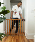 Man using Stairway Baby Gate For Stairs And Doorways Fits 30 To 48 Inch Openings 32 Inch Tall Oak Wood Safety Gate For Doorways