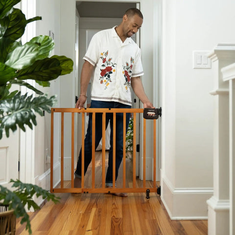 Man using Stairway Baby Gate For Stairs And Doorways Fits 30 To 48 Inch Openings 32 Inch Tall Oak Wood Safety Gate For Doorways