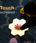 Child interacting with 7 Piece Tap Tap Sensory Lights Kit with Touch and Remote Control Multicolor Magnetic Hexagon Tiles.