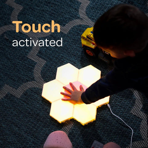 Child interacting with 7 Piece Tap Tap Sensory Lights Kit with Touch and Remote Control Multicolor Magnetic Hexagon Tiles.