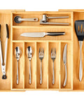 Straight Up Expandable Bamboo Kitchen Drawer Organizer With 2.5 Inch Elevated Sides And Curved Grooves with utensils and cutlery.