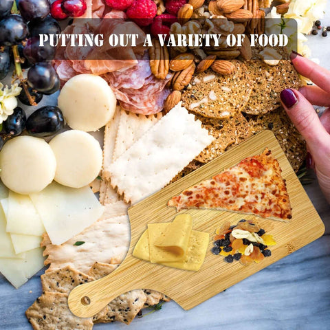 Top view of 11x5 in wooden mini charcuterie board with handle amid cheese, crackers, grapes.