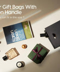 Paper gift bags with ribbon handle next to a book, lipstick, perfume, and small gift, promoting versatility and size inquiry.