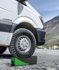 Camper Leveling Kit For RVs Up To 35,000 Lbs With Curved Levelers Wheel Chocks and Anti Slip Mats on gravel surface