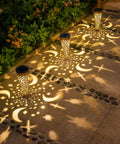 Moon Star Solar Garden Stake Lights Outdoor Waterproof Copper Finish casting patterns on patio pathway at night