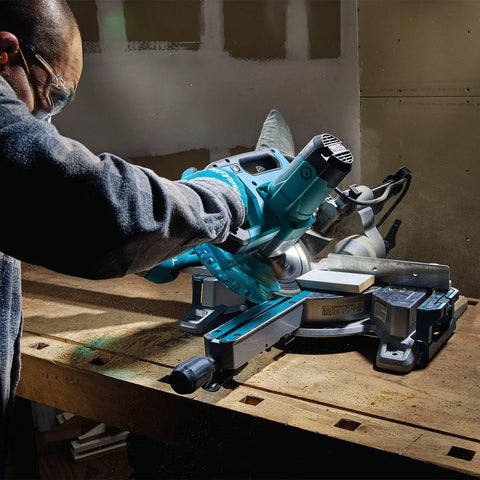 Person using Eight And A Half Inch Sliding Compound Miter Saw With Ten Point Five Amp Direct Drive Motor Packs Five Thousand RPM Bevels Zero To Forty Seven Degrees Portable Thirty Point Six Pounds Cuts Up To Twelve Inches At Ninety Degrees on a workbench.