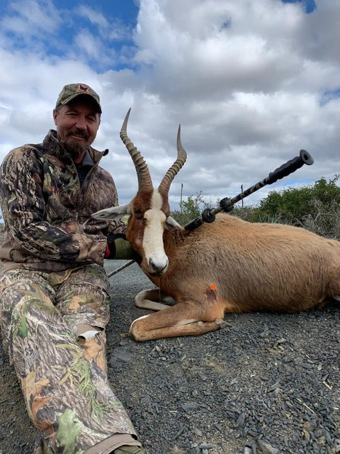 Person in camouflage with antelope, showcasing Slock Master Blow Gun 5 Foot Long 625 Big Bore Caliber with Pistol Grip Dart Quiver.