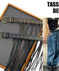 Vintage Industrial Waist Belt Featuring Heavy Copper Hardware And Flowing Tassels With Easy Adjustable Strap In Warm Coffee Brown For Daily Wear That Gives Serious Drip worn with loose jeans and contrasting black top.