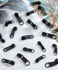 Zipper Puller Replacement Kit 32 Pieces In Four Sizes displayed on a table, black durable plastic beads, DIY tools for coats and luggage.