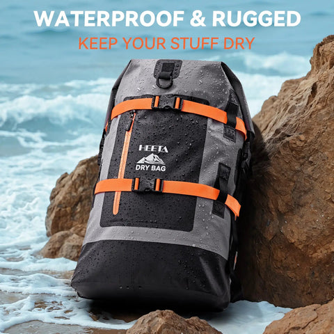 Waterproof Dry Bag Backpack 40L for Men and Women Roll Top on rocks by the sea, grey with orange straps, rugged and heavy duty.