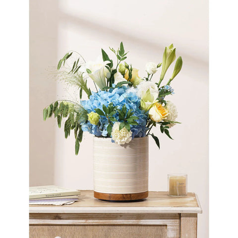 360 Degree Rotating Extra Large Ceramic Utensil Holder for Countertop With Rotatable Wooden Base Deep Capacity Kitchen Utensil Crocks Arctic White Farmhouse Decor displaying a floral arrangement on a wooden countertop.