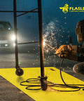 Worker welding with sparks on Heavy Duty Welding Blanket 10x12 Fireproof Spark Guard For Welding, Cutting And Soldering, Heat Safe To 1472 F, Yellow Protective Cover For Sparks, Slag, And Fires In Your Workshop placed on floor.