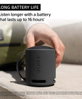 Person holding black XB100 Wireless Bluetooth Portable Speaker With Deep Bass IP67 Waterproof Dustproof Super Compact Travel Buddy 16 Hour Battery Life Versatile Strap Hands Free Calling Black