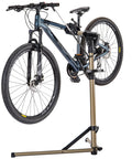 Heavy Duty Bike Repair Stand With 360 Degree Rotating Clamp Holds 1 In To 1.75 In Tubes Rubber Protected 80 Lb Capacity Pro Grade Workstand For Mountain And Road Bikes At Home Or Shop holding a mountain bike