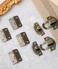 Retro Antique Bronze Small Box Hinges Kit For Wooden Boxes And Jewelry Boxes displayed on a table with latches and screws