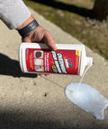 Person pouring Oil Stain Be Gone Overnight Cleaner For Concrete Driveways Pavers And Garage Floors With Oil Eating Microbes on pavement