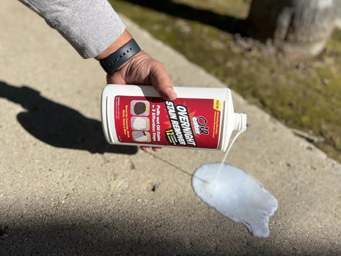 Person pouring Oil Stain Be Gone Overnight Cleaner For Concrete Driveways Pavers And Garage Floors With Oil Eating Microbes on pavement