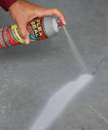 Applying white 14 oz waterproof rubber spray on sealant coating that stops leaks instantly flexible after drying ideal for gutters wood RVs campers roofs skylights windows and more on a crack.