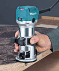 Beefy One And One Quarter Horsepower Compact Router Kit With Variable Speed From 10000 To 30000 RPM Rack And Pinion Fine Depth Adjustment Slim Ergonomic Body And Quick Release Cam Lock For Precise Comfortable Woodworking in use on wooden surface
