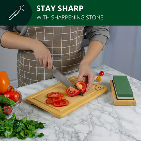 Person slicing tomato with knife beside Dual Grit Whetstone Knife Sharpening Stone 1000 And 6000 on bamboo base