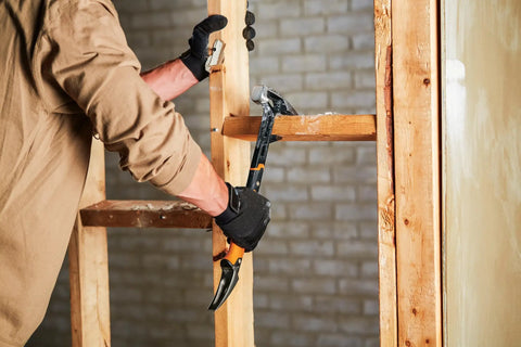 IsoCore Wrecking Bar 18 Inch Board Bender And Crowbar With Shock Absorbing Handle in use for prying wooden beams on construction site