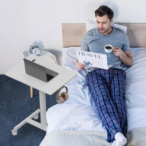 Person using Mobile T Shaped Pneumatic Height Standing Desk On Lockable Wheels Sit To Stand Adjustable Desk in bedroom
