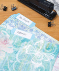 Floral Fun File Folders Bulk Pack Of 24 With Six Decorative Designs on desk with stapler and clips