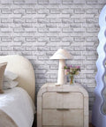 3D Faux Brick Peel And Stick Tiles Set Of 10 Small 11.8 By 11.8 Inch PVC Wall Panels in warm white installed on bedroom wall