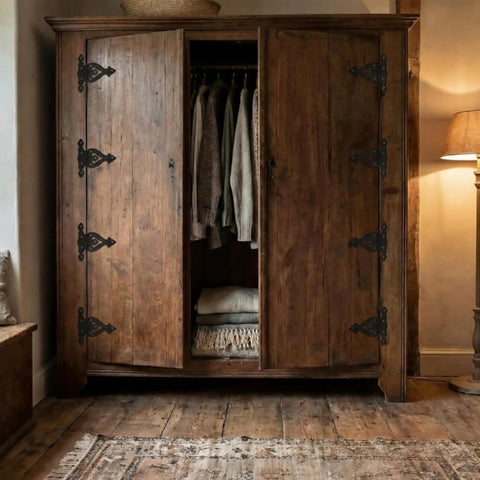 Vintage Antique Cast Iron T Hinges For Cabinet Doors 5 Point 3 Inch on a rustic wooden wardrobe with clothing inside.