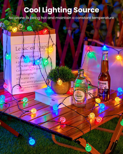 Outdoor 35Ft String Lights With 10 Shatterproof LED Bulbs Waterproof Patio Lanterns For Backyard Deck Garden Parties And Holiday Decor Create A Warm Cozy Glow And Vintage Industrial Vibe For Any Outdoor Space on a wooden table with drinks and plants.