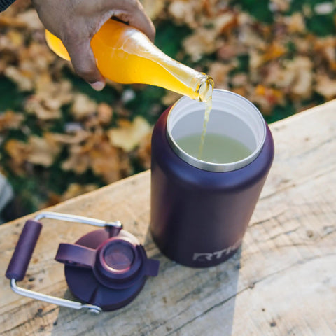 Half Gallon Stainless Steel Water Jug With Ceramic Lined Interior Double Wall Insulated Cooler Bottle being filled with beverage.