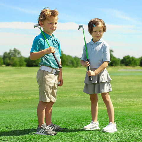 Junior golfers practicing with clubs in a field, showcasing the Junior Golf Club Set For Ages 3 To 5 Left Handed Beginner Starter Kit.