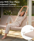 Woman relaxing on a 3-seat outdoor porch swing with stand and canopy, thick cushion, and adjustable backrest.