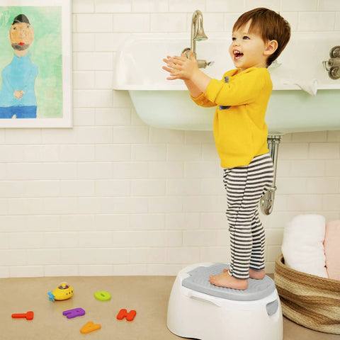 Toddler on The Real Deal Toddler Potty Training Chair 3-In-1 Potty Seat With Step Stool, gray step stool in bathroom.