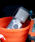 60 Day Portable LED Lantern with 1200 Lumen Power, Lifetime LED Bulbs in orange bucket with climbing shoes