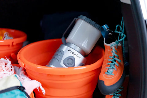 60 Day Portable LED Lantern with 1200 Lumen Power, Lifetime LED Bulbs in orange bucket with climbing shoes
