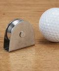 Heavy Duty V Groove Pulley Wheel 304 Stainless Steel Flagpole Riser Kit on wood surface with a golf ball for scale.