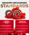 Two metal ball bearings coated in bright red grease on a white background