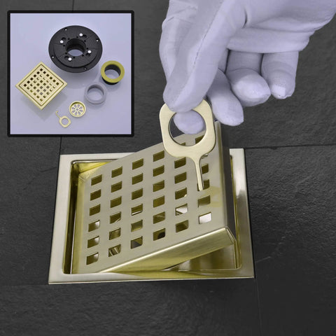4 Inch Square Shower Drain With Adjustable Base Flange In SUS 304 Stainless Steel Removable Grid Cover Sleek Brushed Gold Finish Scratch Resistant Floor Drain For Bathrooms And Showers Easy Clean Upgrade For Modern Wet Areas, shown with hand removing grid cover.