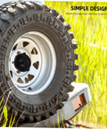 Vehicle wheel secured by Replacement Tire Bolt And Hold Down Clamp For Car Wheels Durable Steel Retainer Versatile Tire Bolt Accessory With Easy Install Fitment For Vehicles Secure Wheel Fastener For Car Truck SUV, shown in grass environment.