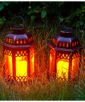 Two Pack Bronze Solar Lanterns With Ornate Retro Hanging Design and LED flickering candle lights in a grassy outdoor setting.