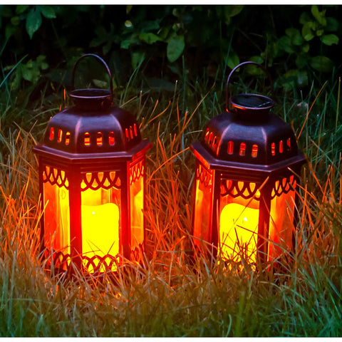 Two Pack Bronze Solar Lanterns With Ornate Retro Hanging Design and LED flickering candle lights in a grassy outdoor setting.