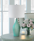 28.25 Inch Tall Porcelain Table Lamp With Teal And Taupe Two Tone Finish next to flowers on a modern living room table
