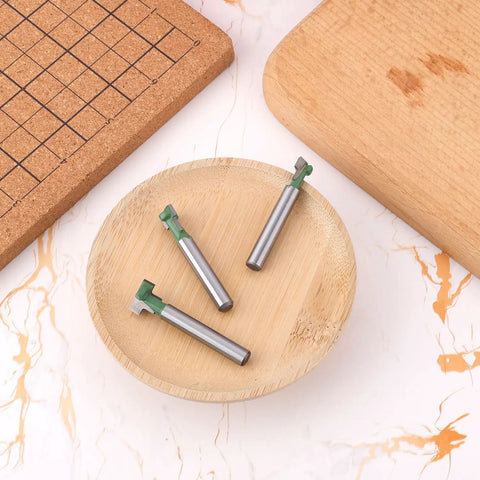 3 Piece Keyhole Router Bits With One Quarter Inch Shank For T Slot Cutting And Hex Bolt Mounting on a wooden plate.