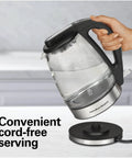 Person holding 1.7L Electric Kettle With Fast Boil 1500W, Water Boiler And Heater, featuring LED indicator and cordless base.